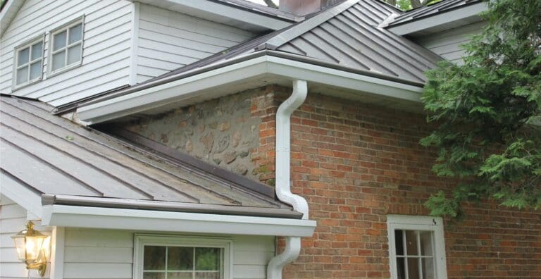 Gutter Installation in Troy on a brick house with metal roofs. Do gutter guards increase home value?
