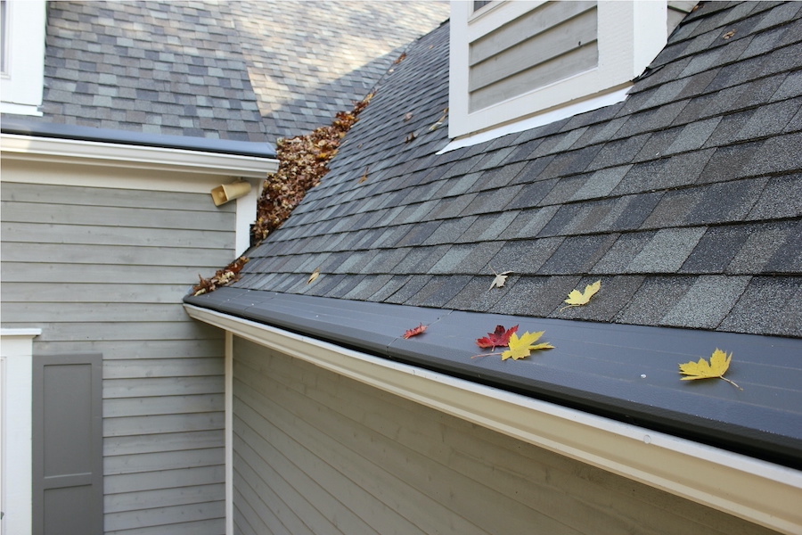 Different types of gutter guards installed on residential gutters for debris protection